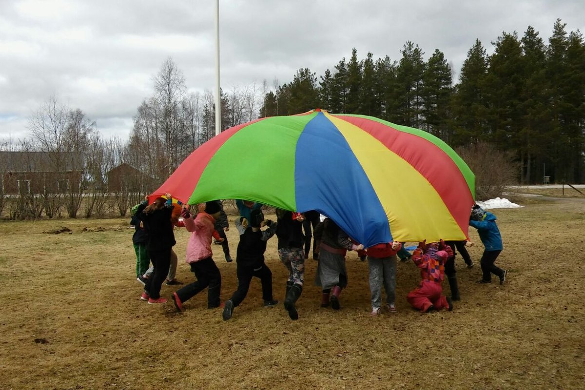 koululaiset leikkivät leikkivarjolla.